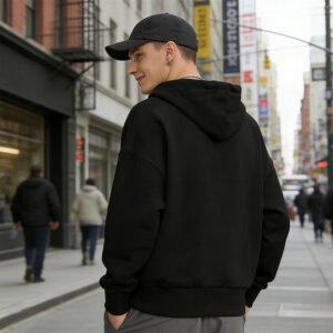 Man wearing a black pullover hoodie with a rhinestone spider motif