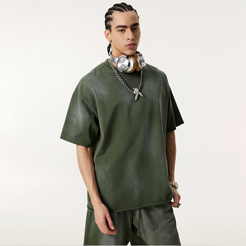Man wearing a green sun-faded oversized raw-edge t-shirt