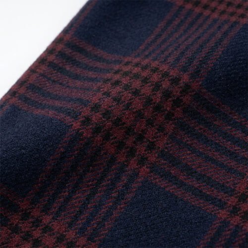 Close-up of navy and burgundy plaid fabric with towel embroidery detail