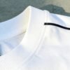 Close-up of a white bomber jacket collar with ribbed texture and a black stripe.
