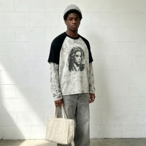 Man in vintage contrast raglan graphic t-shirt and grey jeans