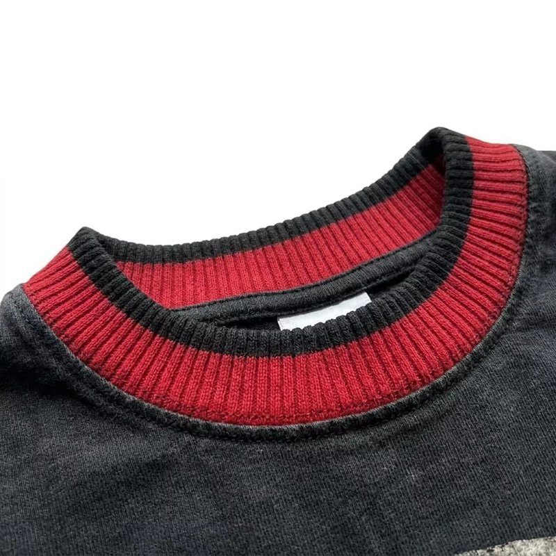 Close-up of a vintage wash t-shirt collar with red and black ribbed stripes.