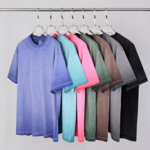 Several vintage washed oversized cotton t-shirts in various colors hanging on a rack.