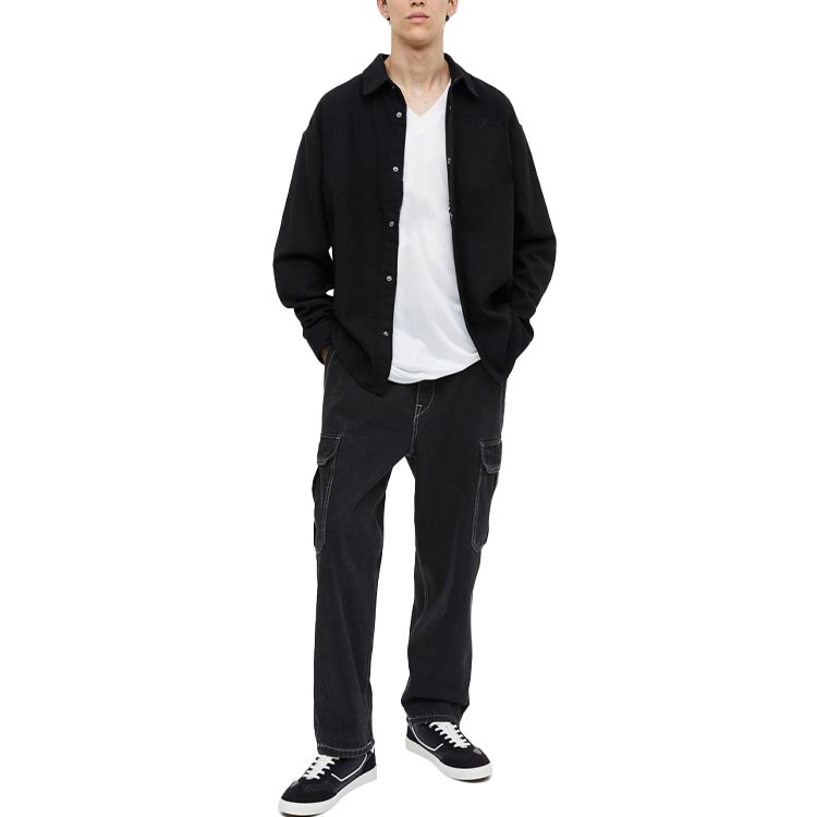 Man wearing black washed custom cargo jeans and a black shirt