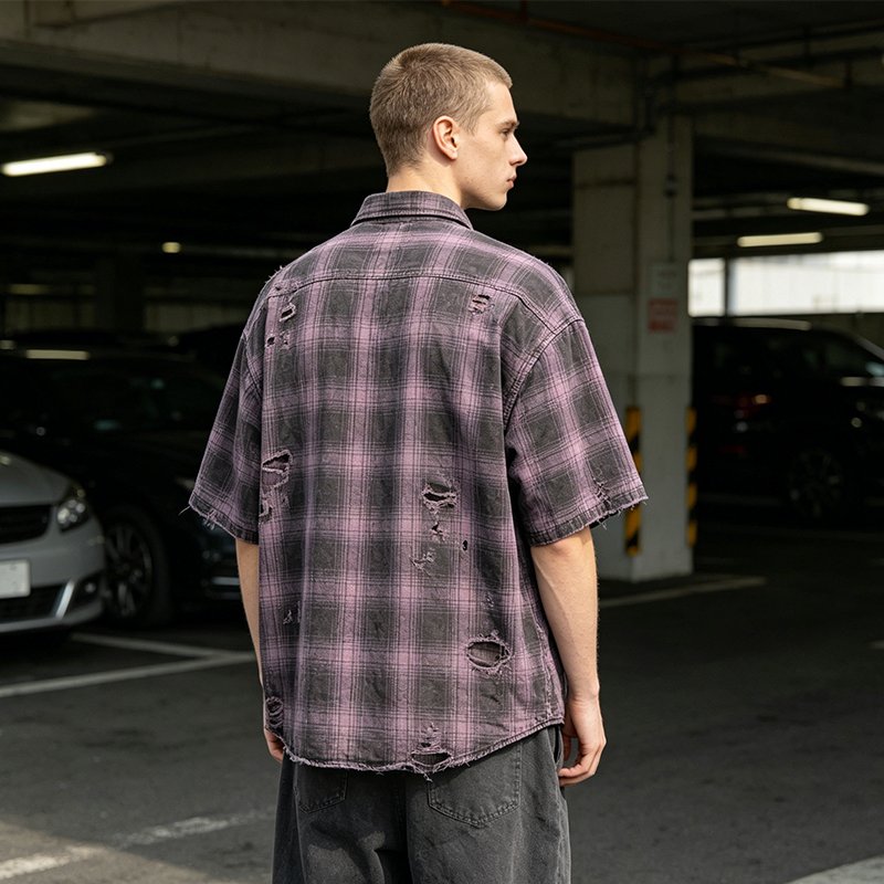Man wearing a distressed purple and black plaid short sleeve shirt