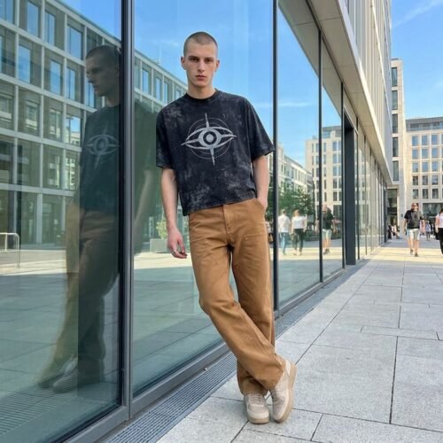 Man in black washed graphic streetwear t-shirt and brown pants