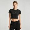 Custom Washed Metal Badge Crop T-Shirt - Style 6CCF22 Woman wearing a black washed-effect crop t-shirt