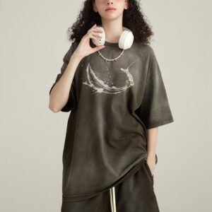 Woman wearing a washed dark grey oversized t-shirt with a graphic print of a sword and moon.