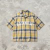 Yellow and blue plaid short sleeve shirt with white 'RAINBOW' text