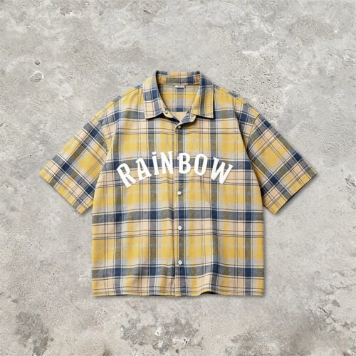 Custom Washed Plaid Rubber Print Short Sleeve Shirt - Style B67ADF Yellow and blue plaid short sleeve shirt with white 'RAINBOW' text