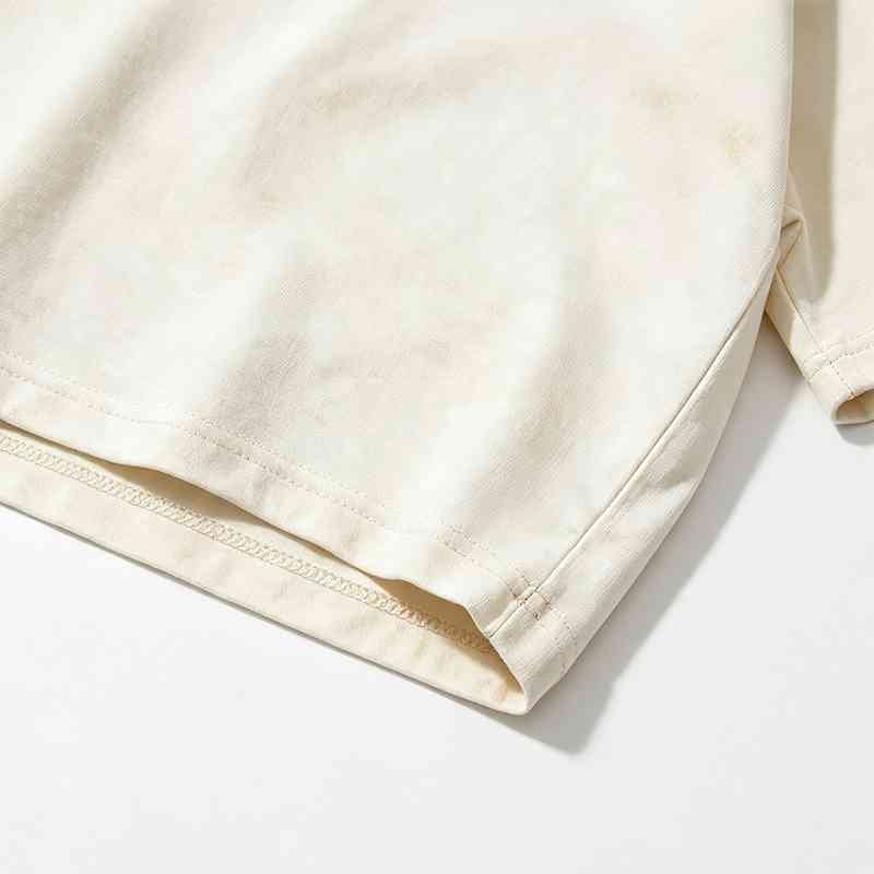 Close-up of a plain, washed cream-colored t-shirt