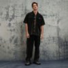 Man wearing a dark washed short-sleeve button-up shirt and cargo pants
