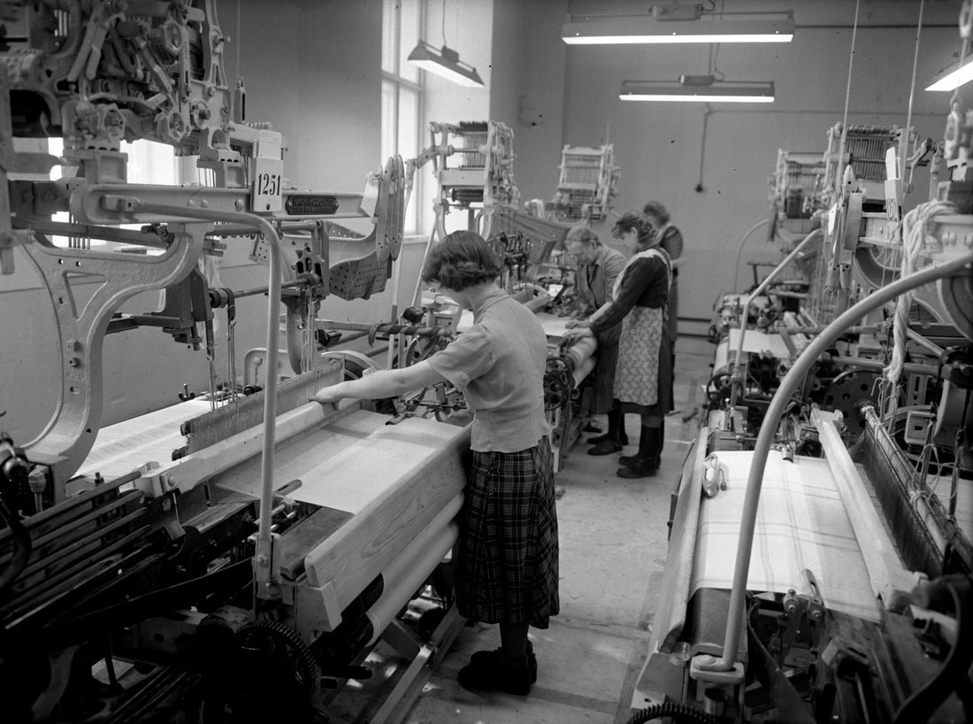 Workers operating looms in a vintage textile factory