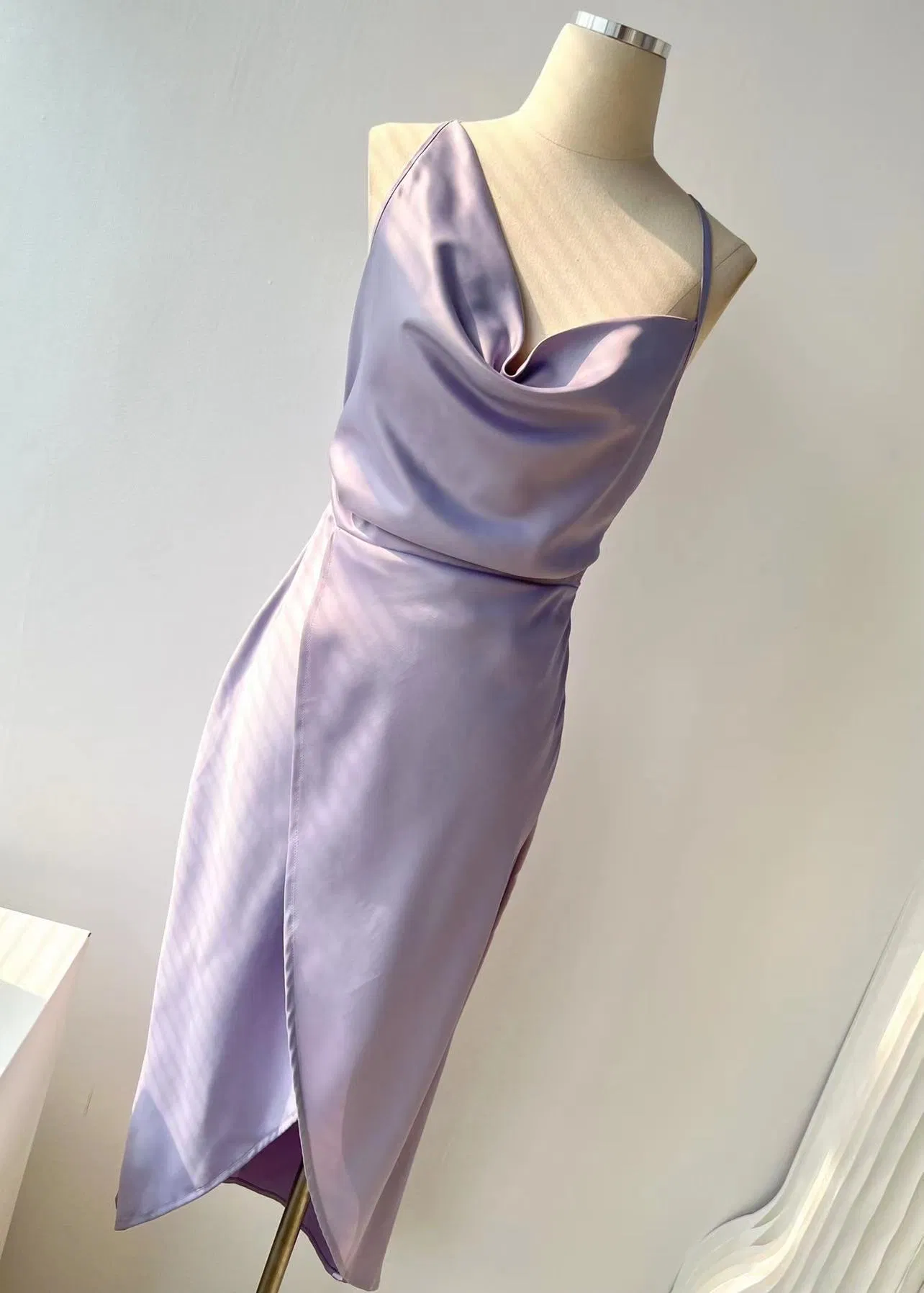 Purple satin draped dress on a mannequin