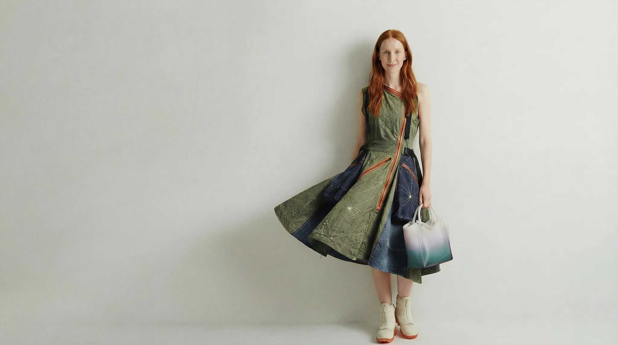 Woman wearing a unique patchwork dress with denim and olive green panels