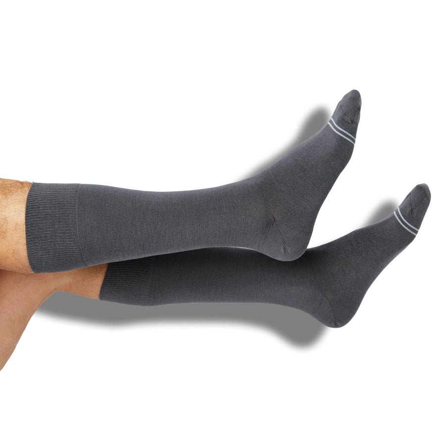Man wearing grey knee-high dress socks with white stripes